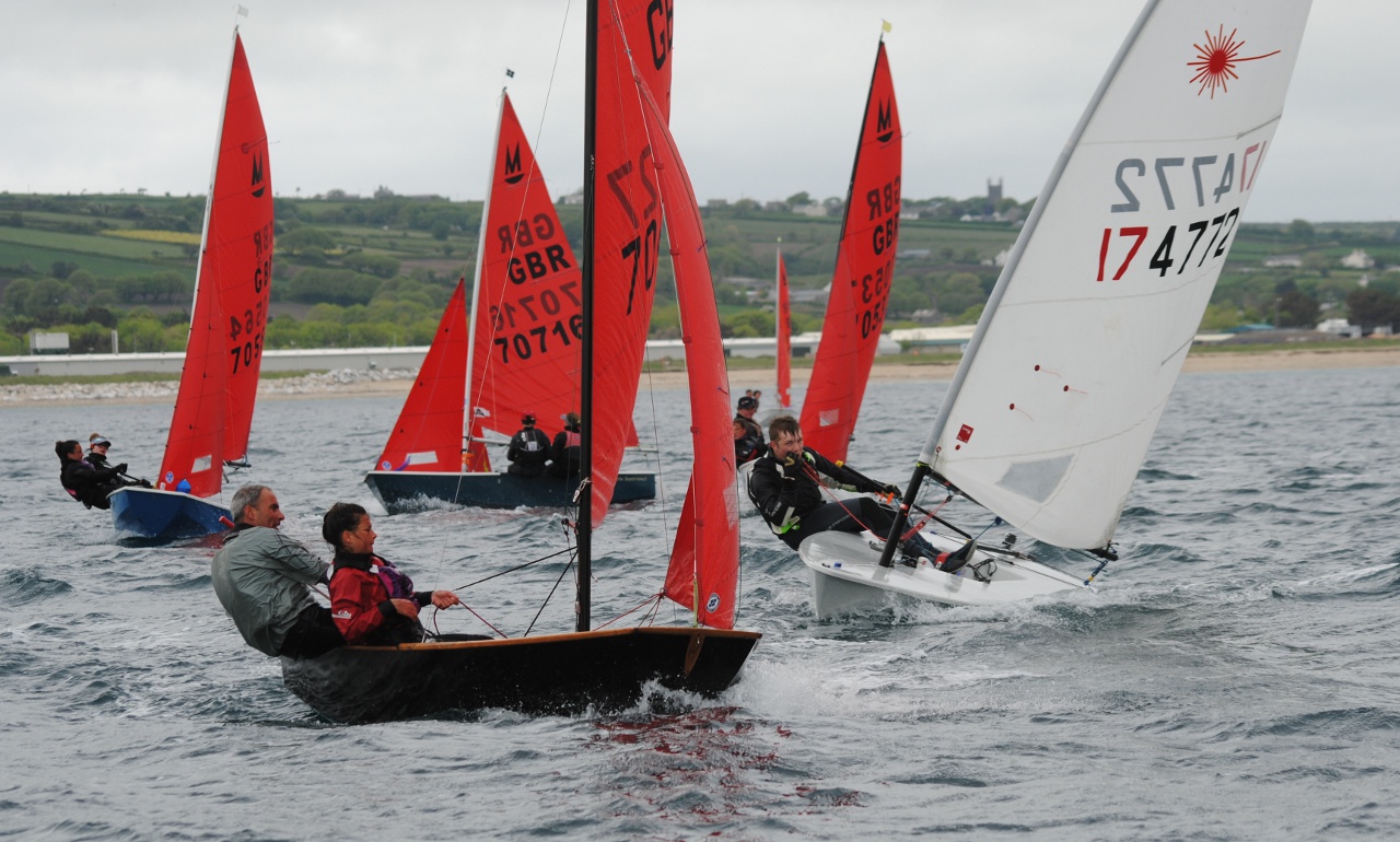 Mirror dinghies and a Laser dinghy racing towards the windward mark