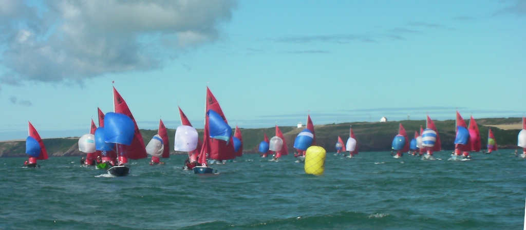 Mirror dinghies running with spinnakers on a sunny day