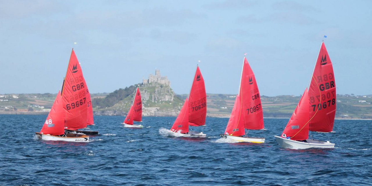 A fleet of Mirrors just after the start of a race with St Michael's Mount in the background