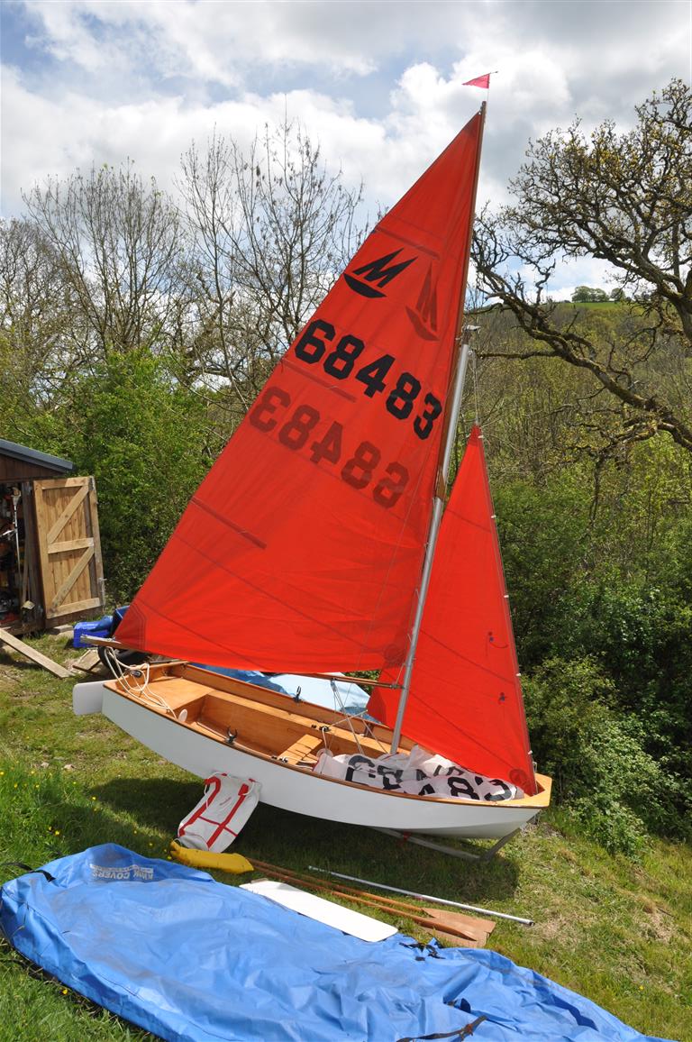 White wooden Mirror dinghy rigged up in a garden