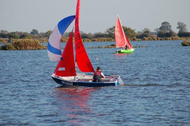 Blue GRP Mirror dinghy sailing singlehanded with spinnaker up