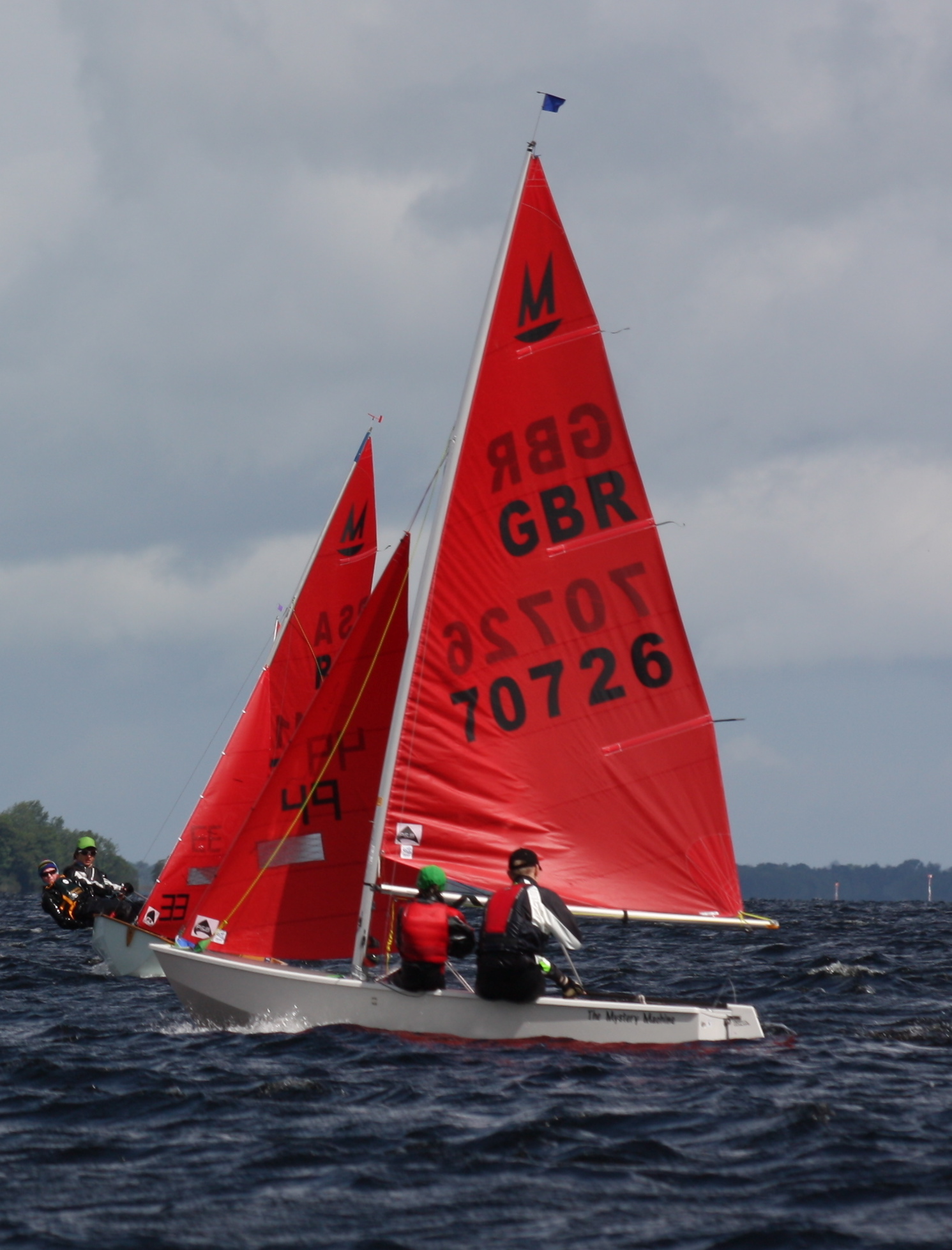 White Mirror dinghy on port about to tack to avoid a Mirror on starboard tack