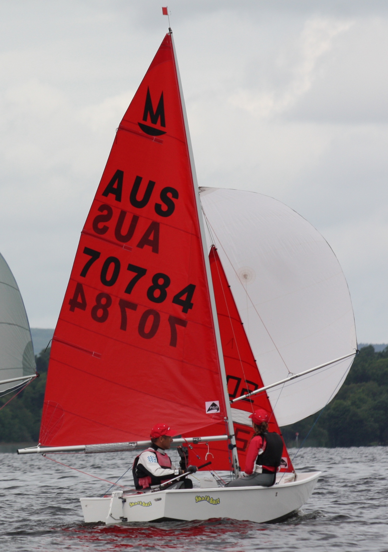 A white Mirror dinghy racing with spinnaker set