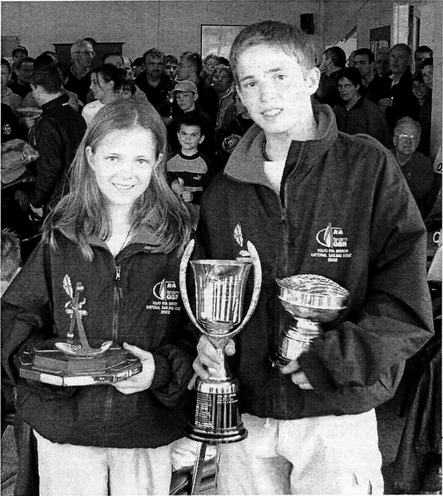 A boy and a girl holding their trophies