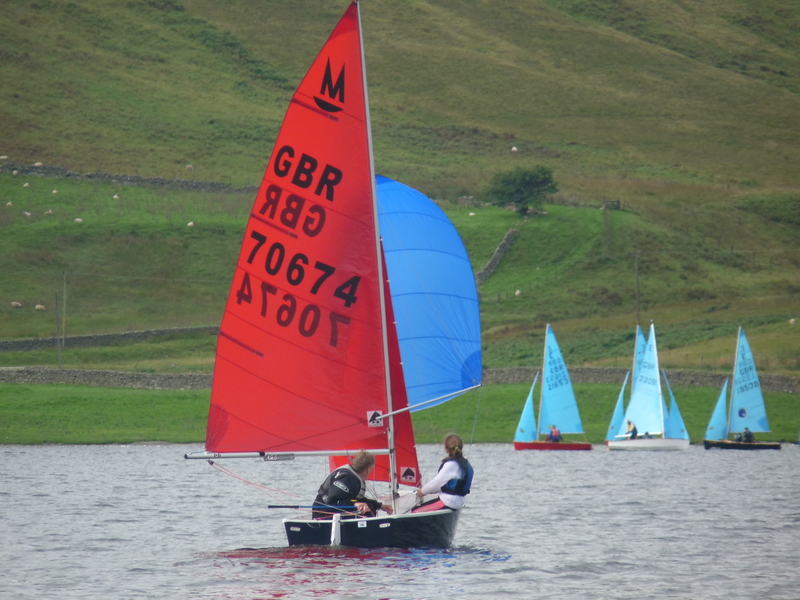 Racing at St Mary's Loch SC in 2012 A Mirror dinghy racing downwind with spinnaker set with Enterprise dinghies in the background