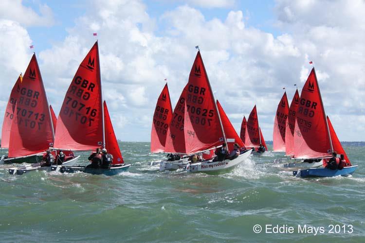A fleet of Mirror dinghies sailing to windward just after the start of a race